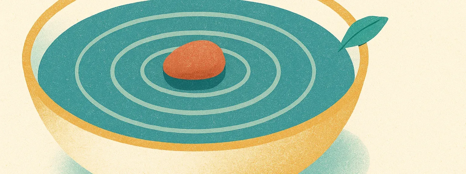 Focus — single pebble at the centre of a shallow bowl of water