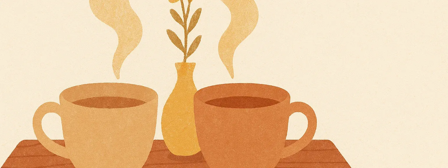Social — two ceramic teacups whose handles face each other on a wooden table